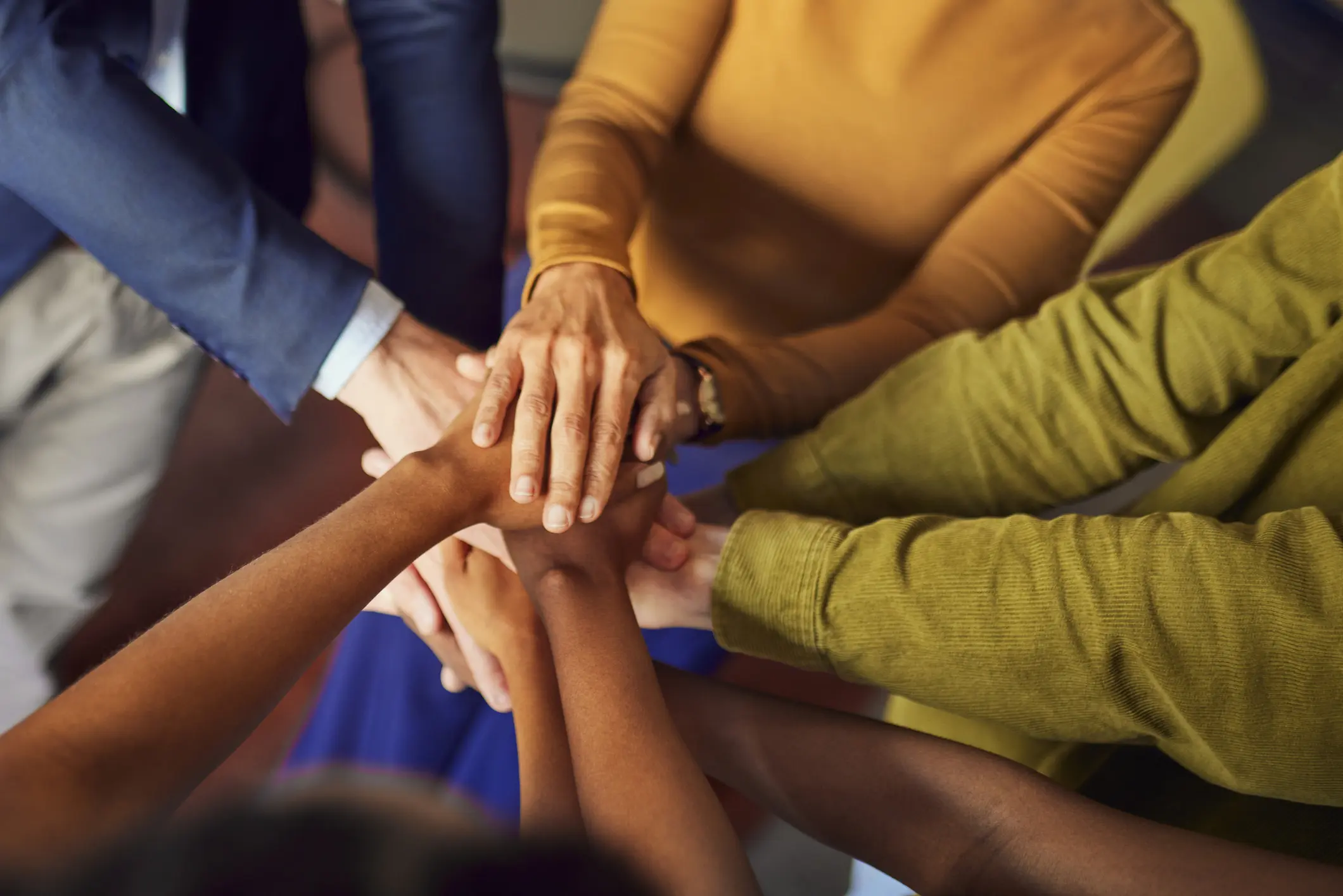 Diverse team stacking hands in unity